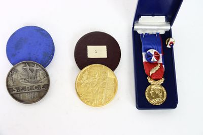 three medals and a medal in a blue case