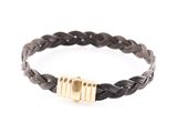 un gros plan sur un bracelet tressé noir muni d'un fermoir doré