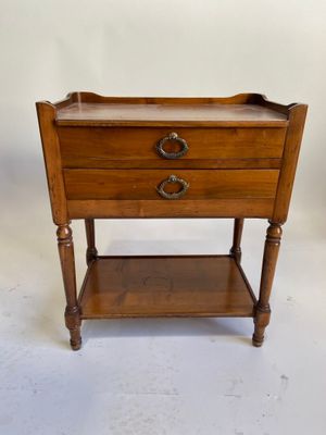 une vieille table en bois avec deux tiroirs et un tiroir en dessous