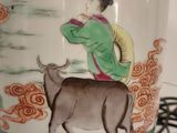 a vase with a picture of a woman and a cow on it