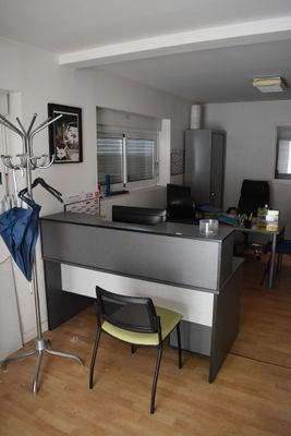 a desk with a chair and a coat rack in a room