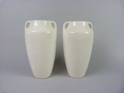 two white vases that are sitting on a table