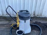 un aspirateur blanc et noir posé sur un sol en béton