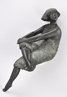 statue d'une femme assise sur une chaise, les jambes croisées