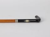 a close up of a cane with a wooden handle on a white surface