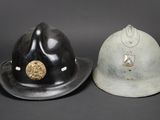 pair of german fire helmets, one with a helmet and the other with a helmet on it