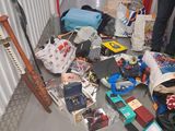 un homme debout à côté d'un tas d'objets divers posés par terre