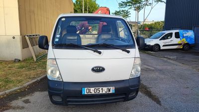 une petite camionnette blanche garée sur le bord de la route