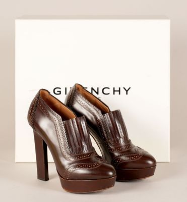 une paire de chaussures marron posée sur une boîte blanche