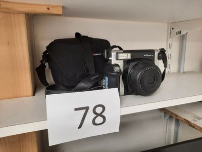 un appareil photo et un sac posés sur une étagère dans un magasin