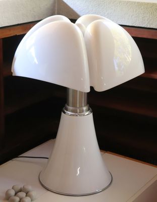 une lampe posée sur une table à côté d'un miroir