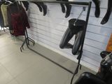 a photo of a clothing store with clothes hanging on a rack