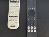 two remote controls sitting on a table next to each other