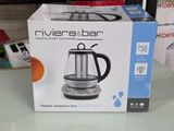 emballage d'une cafetière argentée et noire posée sur une table en verre