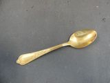 a gold spoon sitting on a black surface