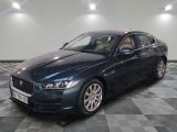 the jaguar car is parked on a checkered floor in a garage