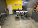 une photo d'un salon avec des chaises et des tables