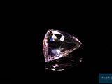 gros plan d'un diamant rose sur une surface noire
