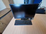 a computer monitor and keyboard on a desk in a room