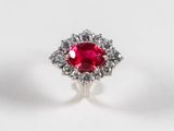 Gros plan sur une bague sertie d'un rubis et de diamants, posée sur une surface blanche