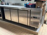 a stainless steel counter with a bunch of bottles on it