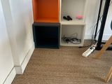 a room with a desk, shelves, and a chair in it