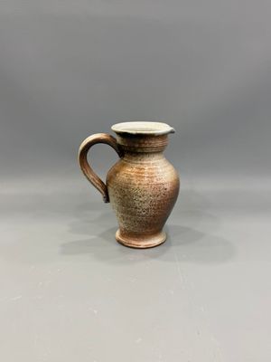 un gros plan d'un petit vase marron posé sur une table