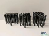 un groupe de stylos noirs posés sur une table blanche