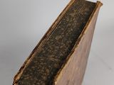 an old book sitting on top of a white surface