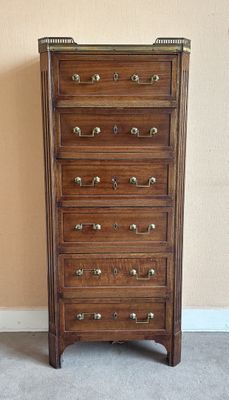 une haute commode en bois dans le coin d'une pièce