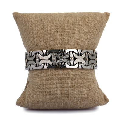 bracelet en argent avec un motif noir et blanc sur un coussin