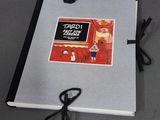 une photo d'un livre posé sur une table, à côté de ciseaux