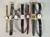 plusieurs montres différentes sont alignées sur une surface blanche