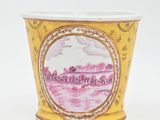 une tasse jaune sur laquelle est représentée une ville