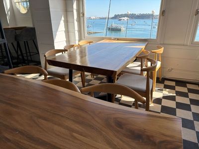 a table and chairs in a room with a view of the water