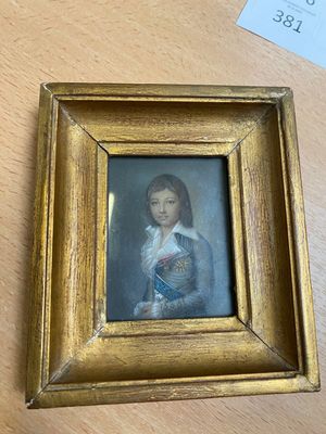une photo représentant un jeune garçon, dans un cadre doré