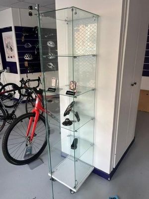 a glass display case in the middle of a room with bicycles