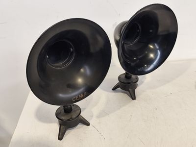une paire d'enceintes noires posées sur une table blanche