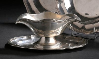 une assiette en argent posée sur une soucoupe et un plateau