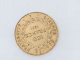 a gold coin on a white surface with a white background