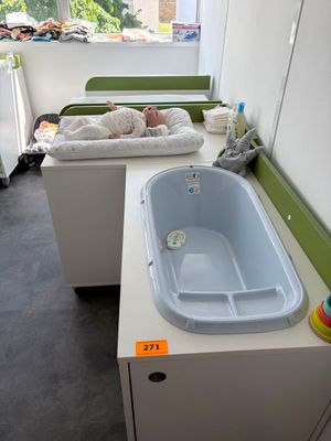un bébé allongé dans une baignoire, dans une petite pièce