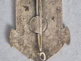 an old silver broochle with a pair of scissors on top of it