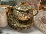 many different types of teapots and cups on a shelf
