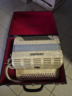 a white accordion sitting in a red case on a tiled floor