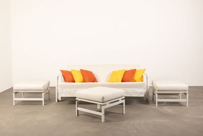 a white couch with orange and yellow pillows in a white room