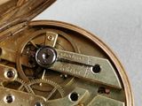 a close up of a pocket watch with gears on it