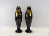 une paire de vases noirs et dorés sur fond blanc