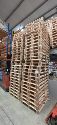 une grande pile de palettes dans un grand entrepôt