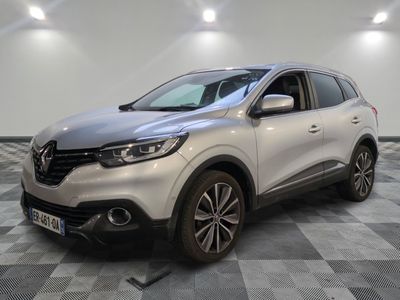 une voiture argentée garée dans une pièce au sol en damier