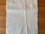 the white towel is folded on a wooden table